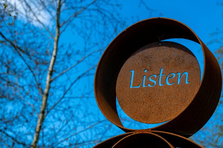 Listen sign against blue sky