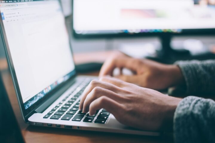 Researcher typing on their laptop